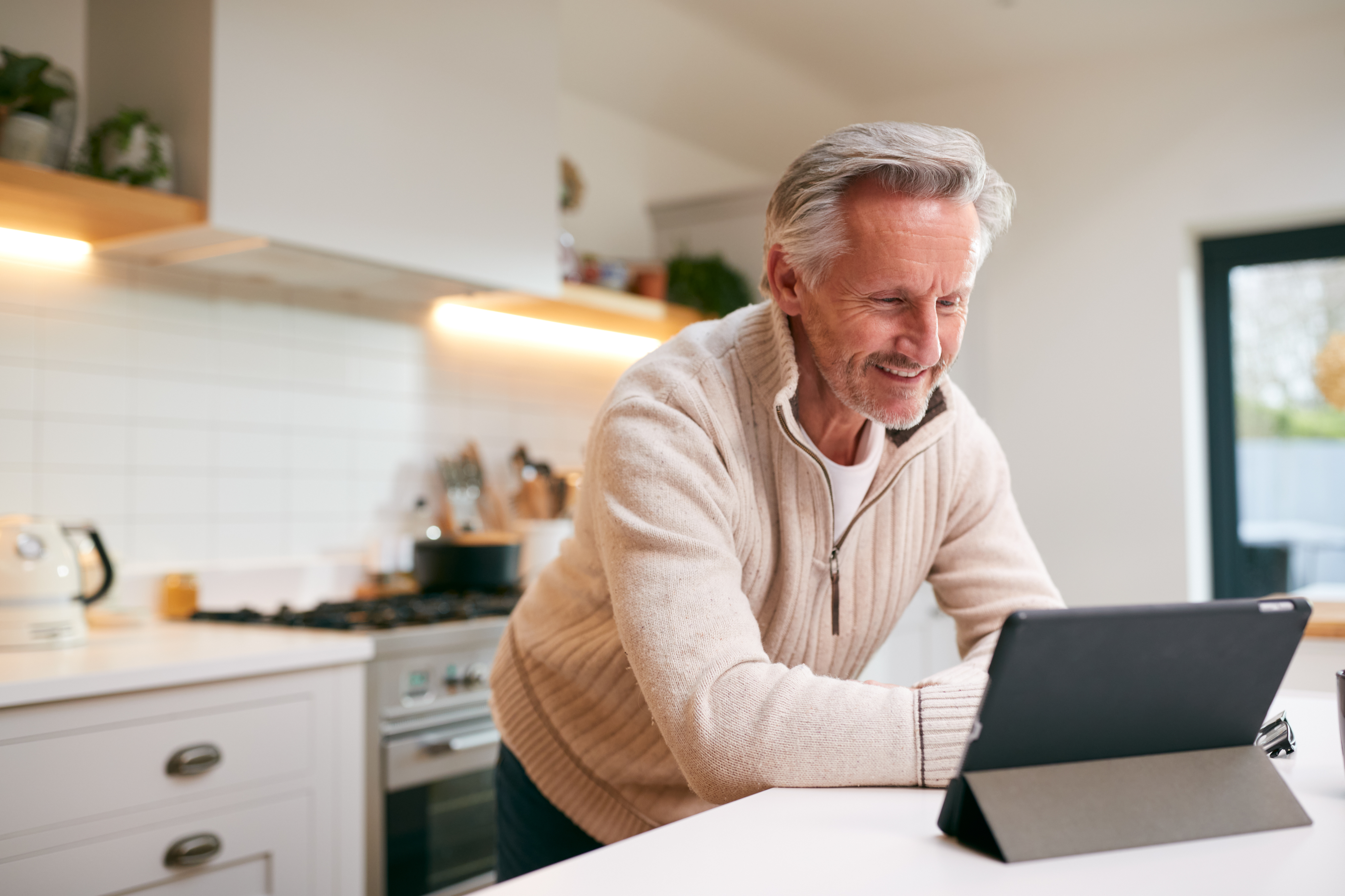Happy senior with glasses working on a laptop