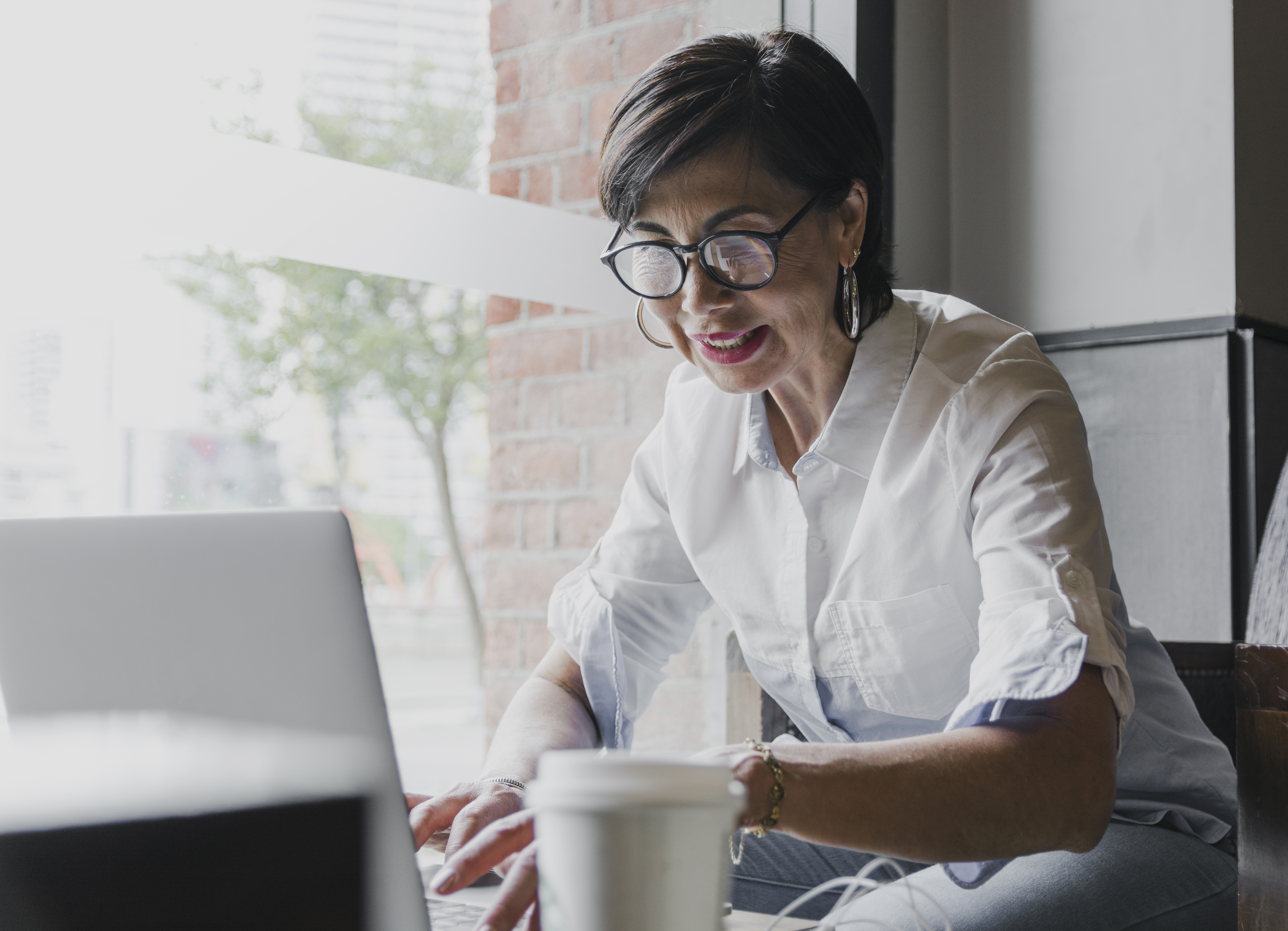 A man with glasses working on a laptop